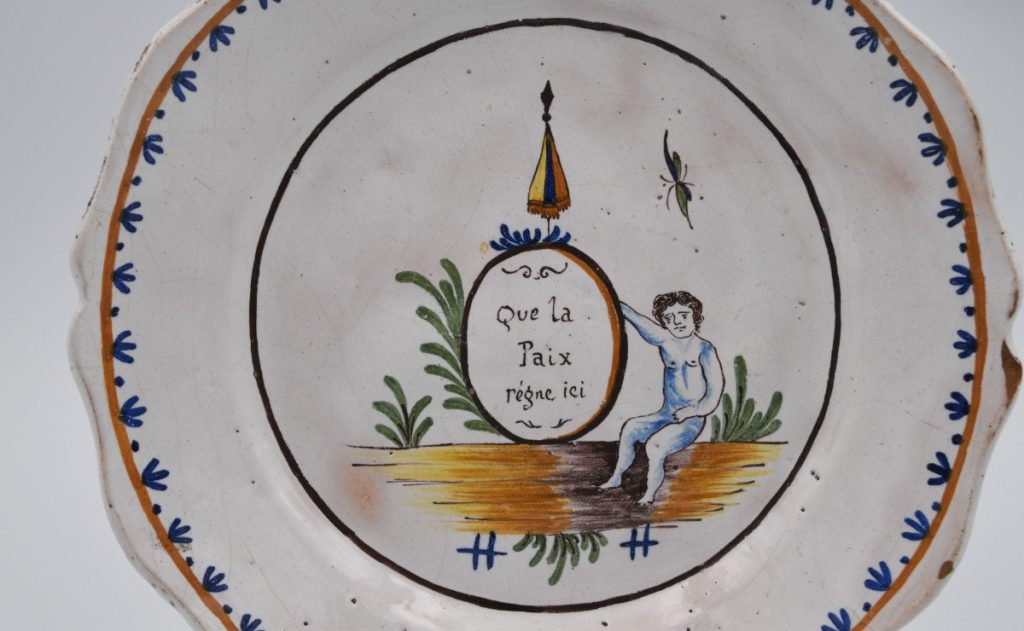 Nevers faience plate during the French Revolution with putto and motto "May peace reign here ".