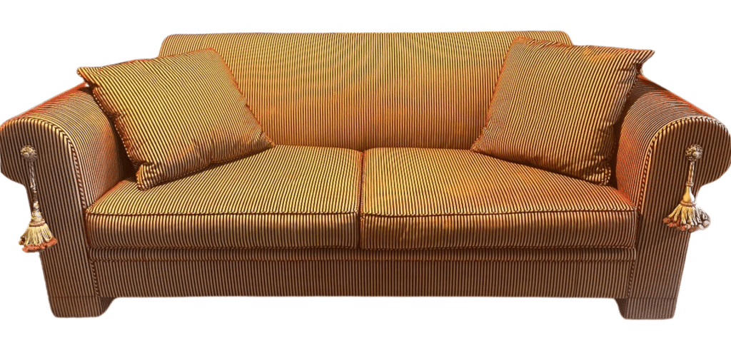 Large designer couch with a red and ocher valvet fabric.