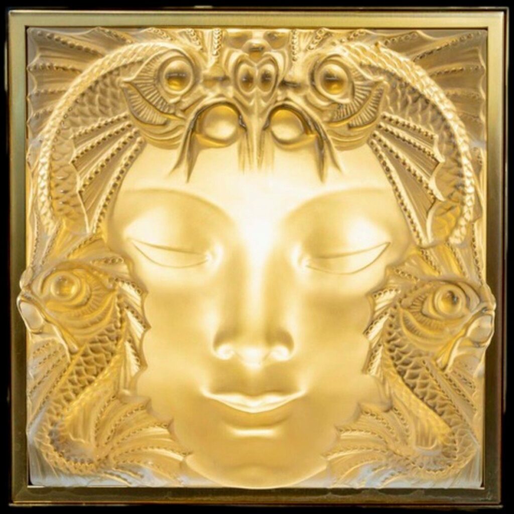 The Woman's Mask ornated with fishes, originally created by René Lalique for the Champs-Elysées fountain, was integrated in several other Lalique artworks.