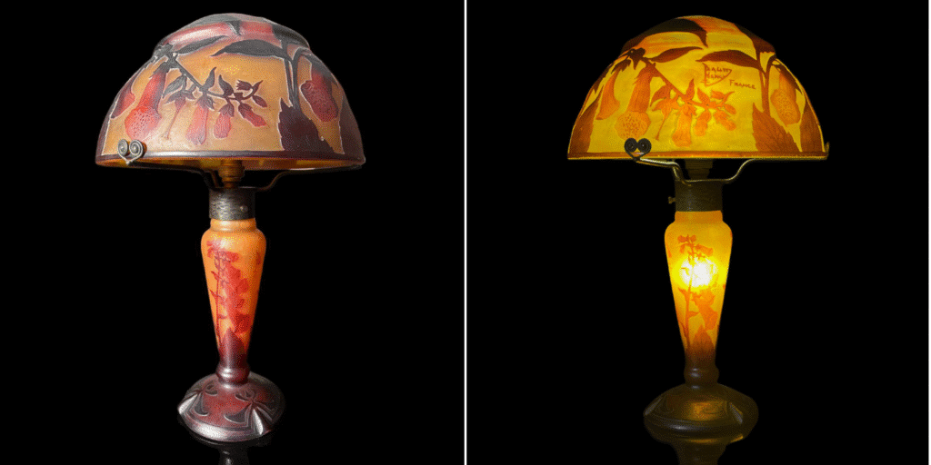 An acid-etched cameo glass lamp by Daum crafted around 1915. The digitalis flowers and stems are in shades of red, orange and brown against a yellow background.