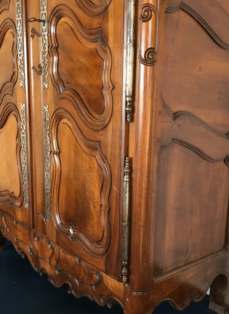 18th-century Provençal wardrobe from Fourques in walnut. Detail showing the typical carving from this area: deep curved double moulding and snail spirals.