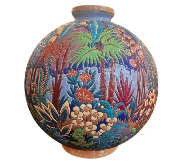 The distinctive globe shape of the most iconic Art deco vase by Longwy enamels. The rich decoration with colorful trees and flowers is best served by the simple shape.