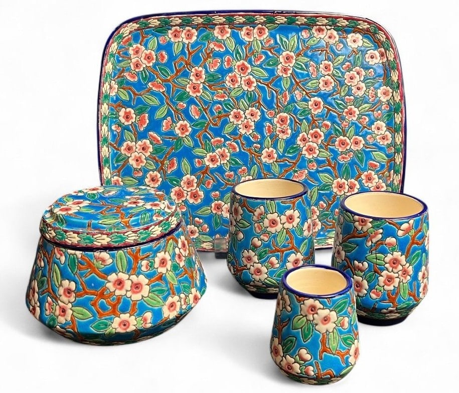 A five-piece Longwy smoking set boasting the famous D188 "apple blossom" decor.