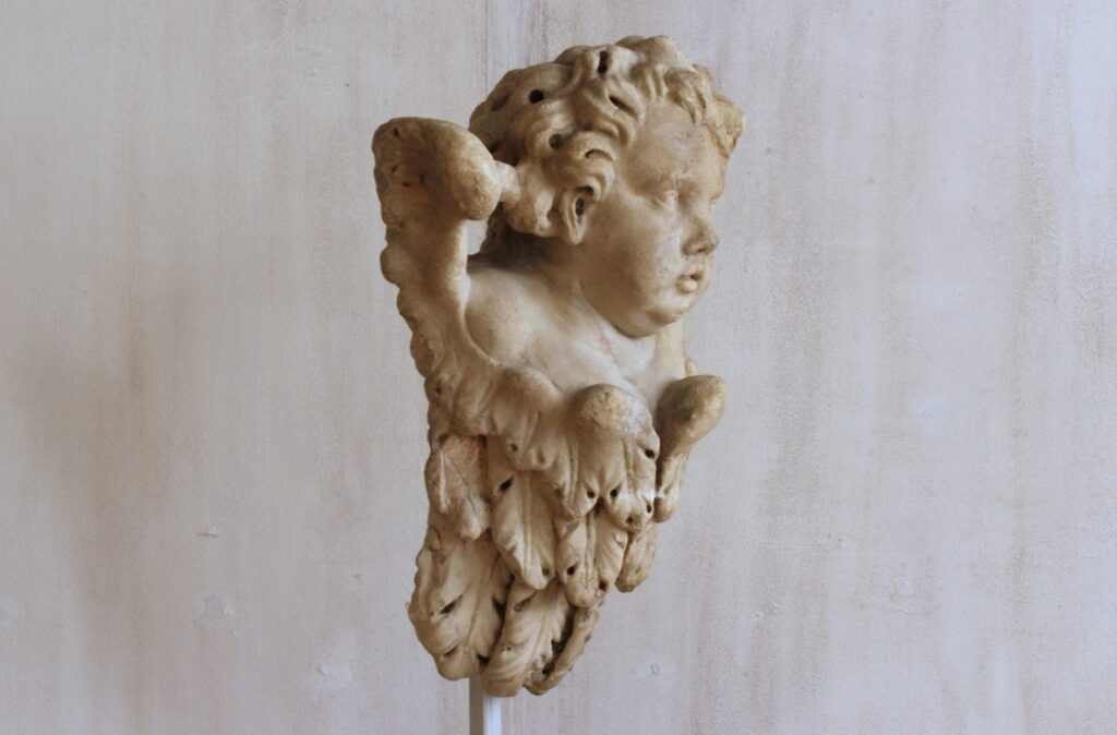 A 17th-century sculpted angel head in marble from Italy.