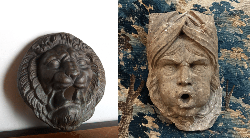Two antique fountain spout mascarons. Left: 19th-century cast-iron lion head. Right: 18th-century limestone aquatic god.