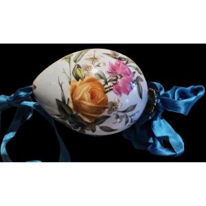 En porcelaine, sur fond azur, cet oeuf de Paques esr decoré d'un bouquet de fleurs peints.