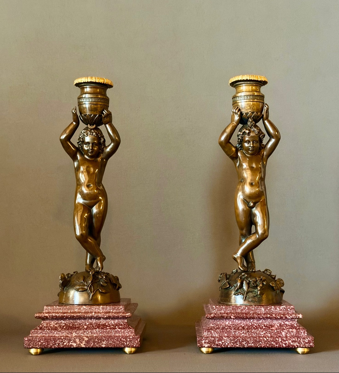 A Pair Of Patinated Bronze Candlesticks With Putti Depicted As Canephores. Circa 1850