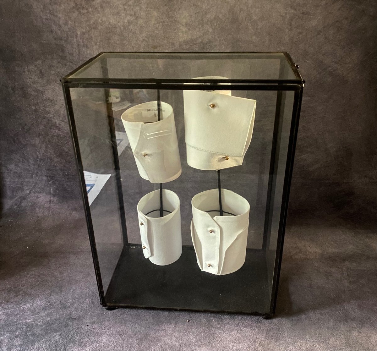 Old Glass And Iron Display Cabinet Containing A Series Of Shirt Cuffs.-photo-2