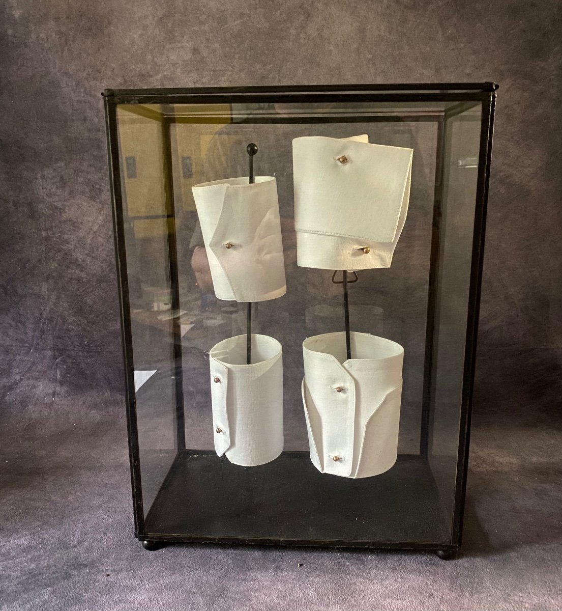 Old Glass And Iron Display Cabinet Containing A Series Of Shirt Cuffs.