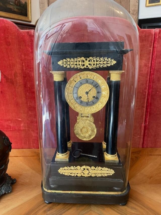 Importante pendule portique en bois noirci avec bronzes dorés sous son globe ancien