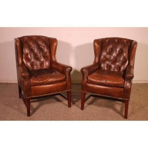 A Pair Of Brown Leather Wingback Chesterfield Armchairs