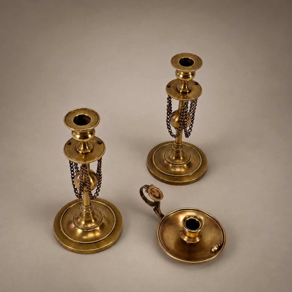 Trois bougeoirs miniatures en bronze et laiton – Flambeaux à chaînettes et bougeoir au scarabée