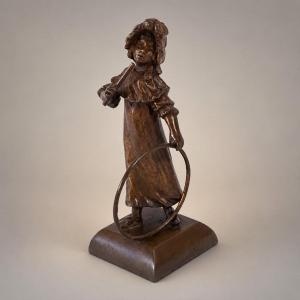 Petit bronze Art Nouveau – Fillette jouant au cerceau – Patine médaille – Sujet de vitrine 1900