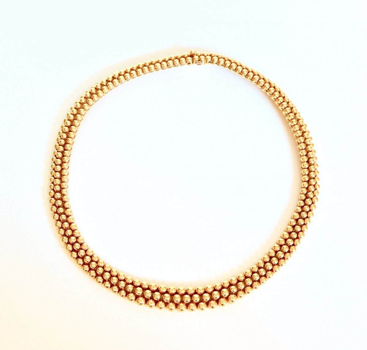 BOUCHERON Collier en or jaune 18 carats formant un ruban de 3 rangs de boules d’or.