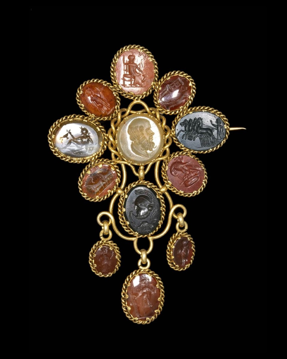 BROCHE VICTORIENNE EN OR SERTIE DE DOUZE INTAILLES SUR PIERRES DURES. SUJETS VARIES.