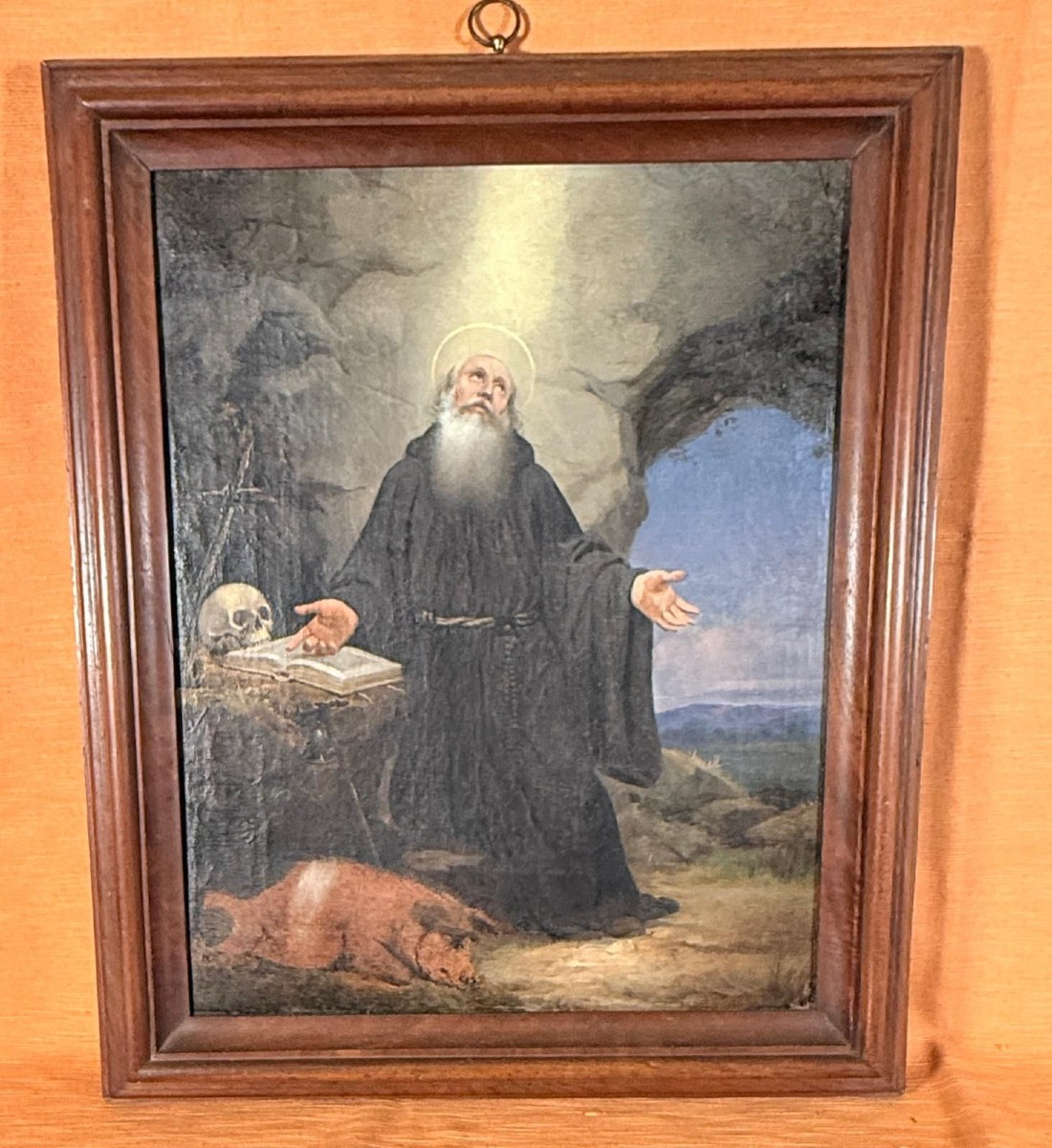 Tableau représentant Saint Antoine l'abbé dans son cadre d'époque du XVIIIe siècle.