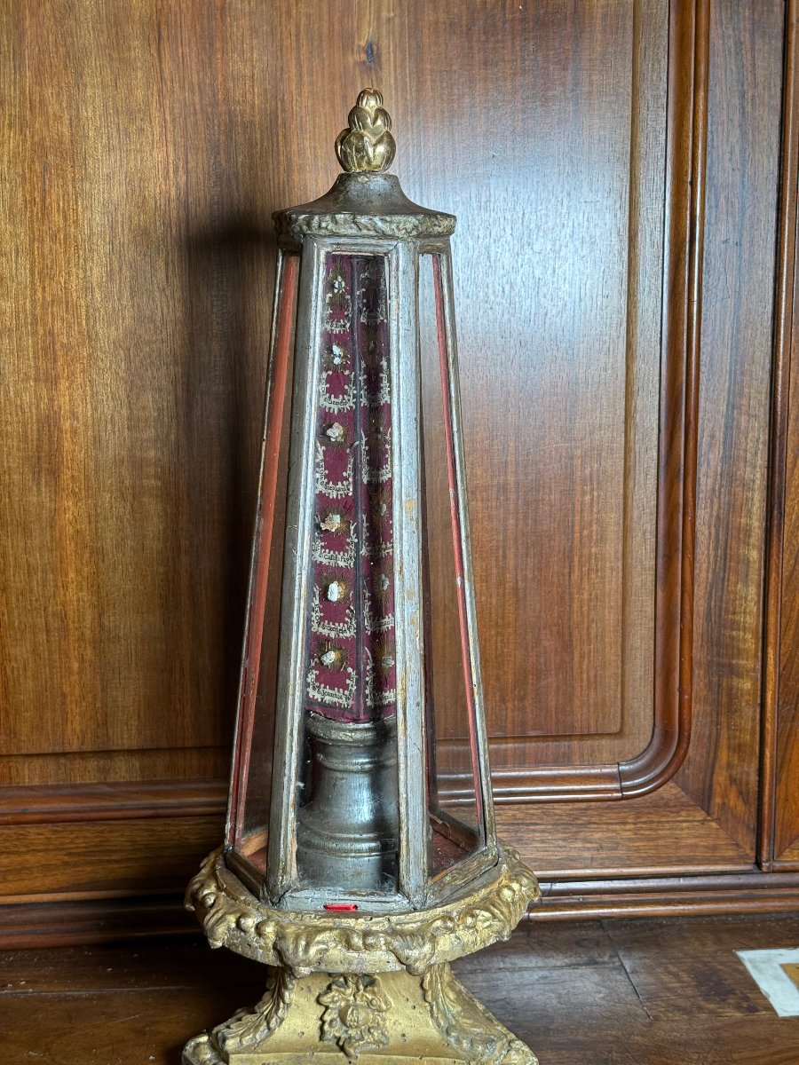 Un reliquaire hexagonal en bois doré, de forme pyramidale, contenant 24 reliques de saints