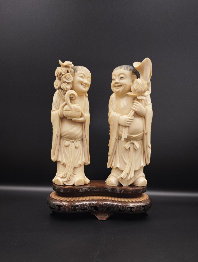 Pair Of Ivory Sculptures Depicting Hehe Twins Holding Flowers, Qing Dynasty, China