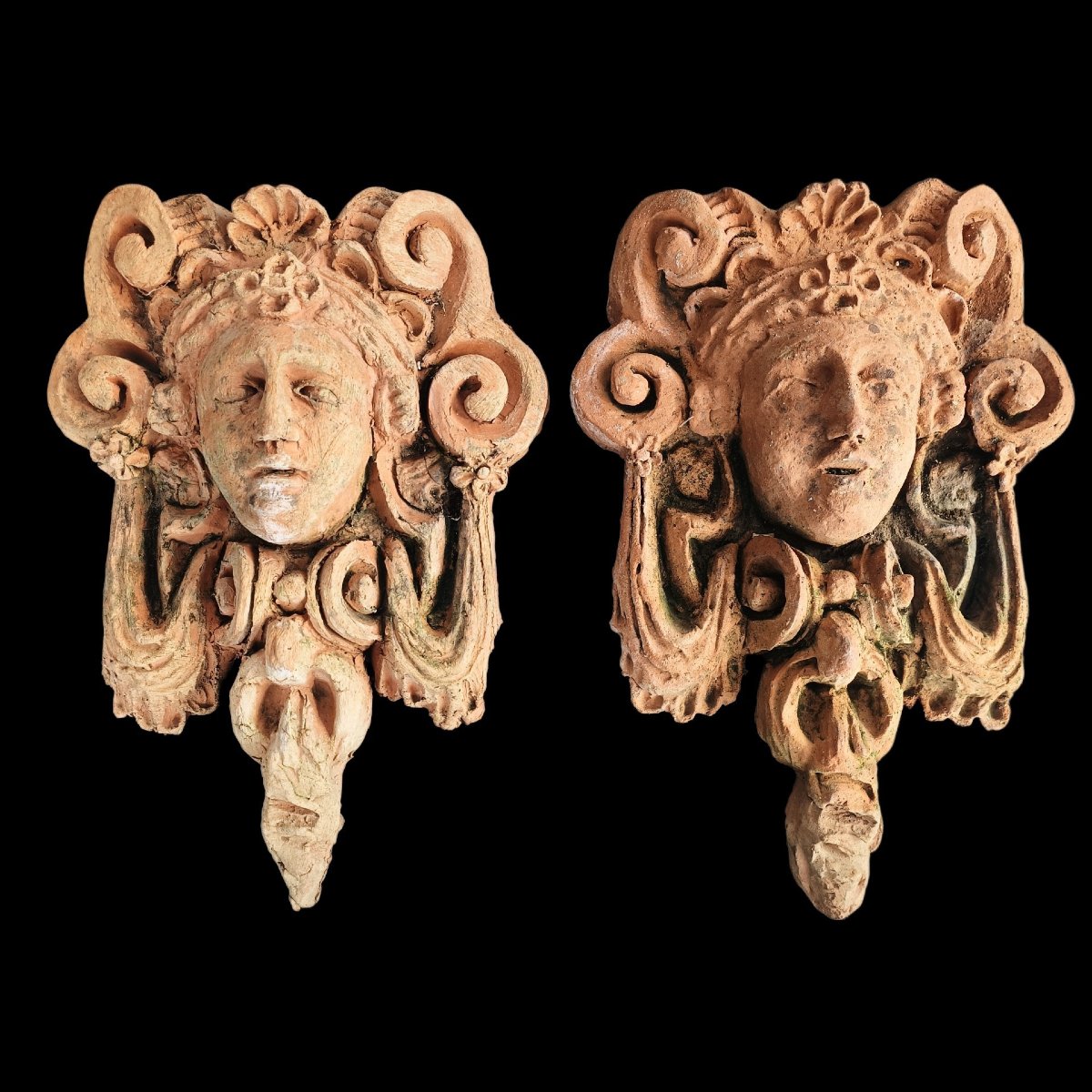Paire de mascarons en terre cuite. Italie, XXe siècle.