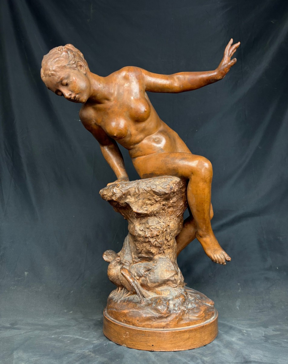Sculpture en terre cuite représentant une nymphe observant deux colombes, signée « Rougelet ».