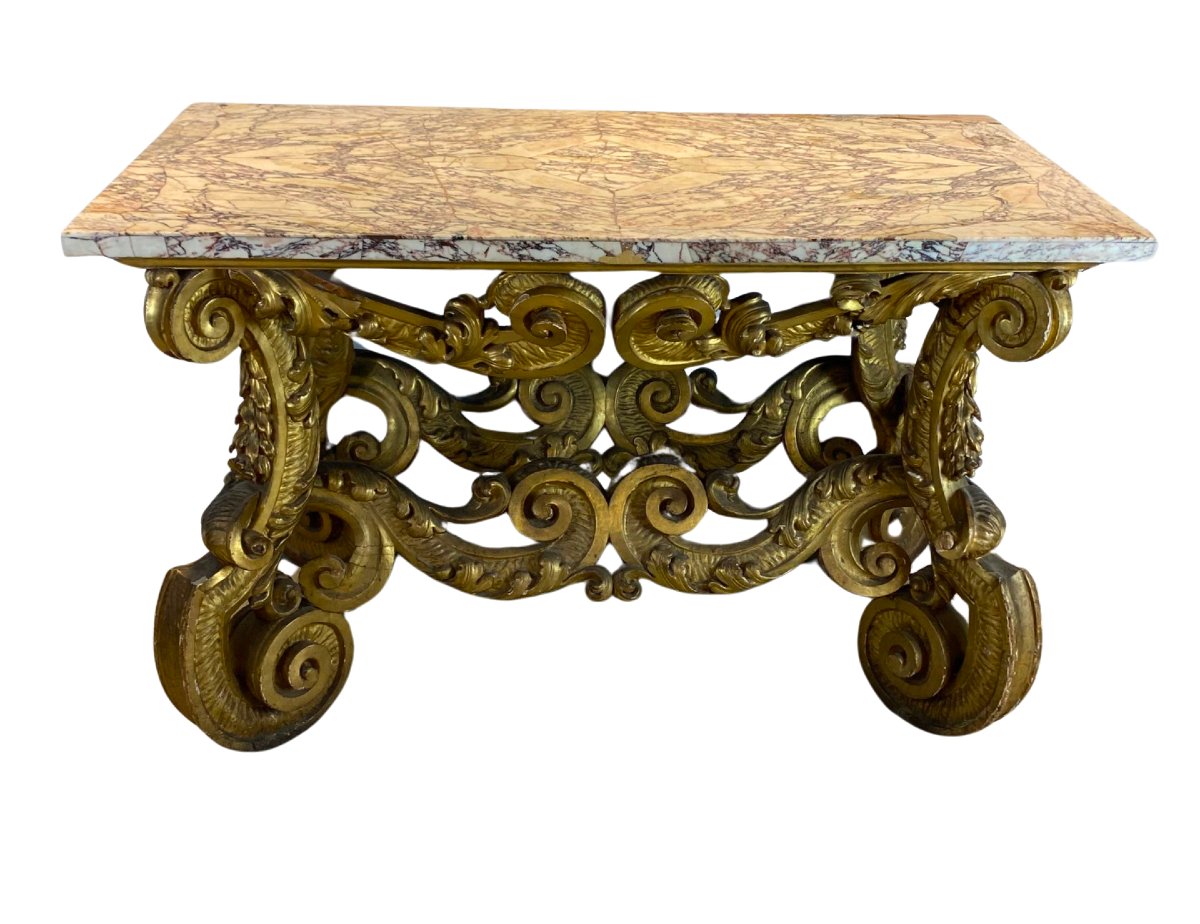 Italian Baroque Console Table In Gilded Wood With A Marble Top Set On A Stone Base.