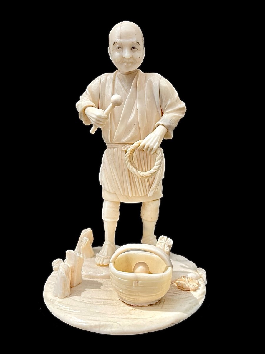 Ivory Okimono Sculpture Depicting A Male Figure With Braid And Basket. 