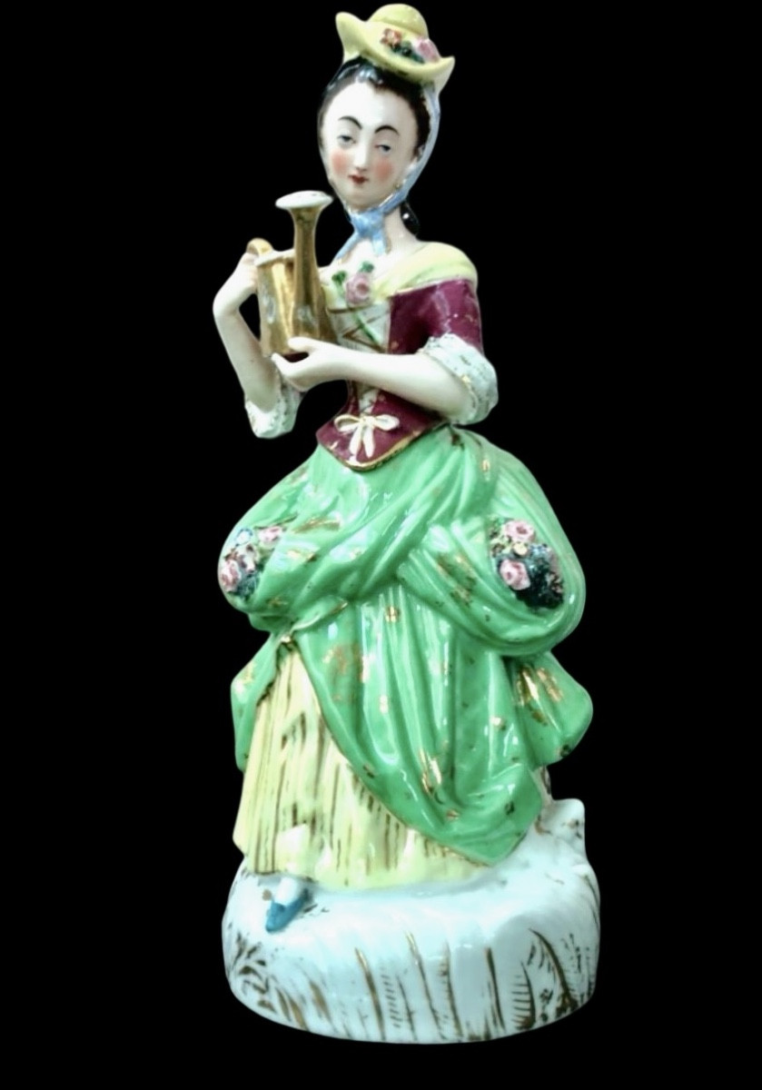 Veilleuse en porcelaine polychrome à rehauts d'or, représentant une dame à l'arrosoir. France,