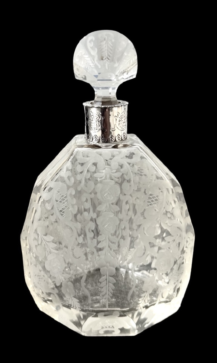 Flacon de parfum en cristal taillé octogonal orné de motifs floraux et rocaille stylisés. 