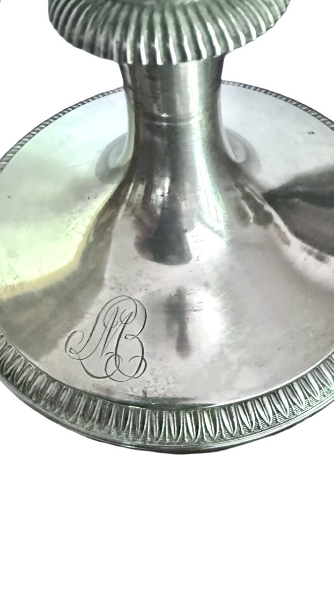 A Silver Coffee Pot With A Pear-shaped Body Resting On A Circular Base Adorned With Lanceolate Leaves.-photo-1