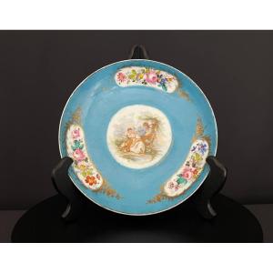 Assiette en porcelaine française  à fond turquoise, décor floral et scène galante, XIXe siècle
