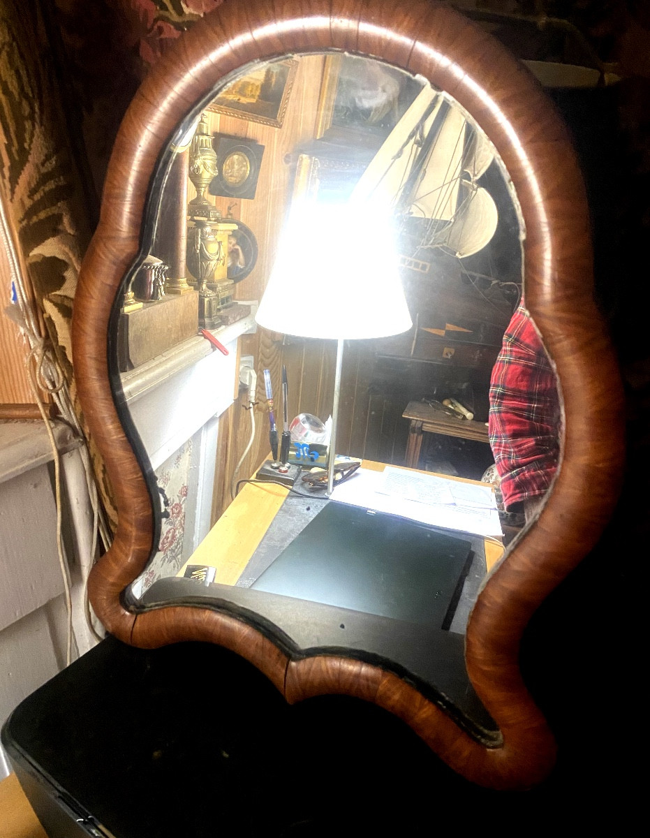 Miroir Louis Philippe de forme chantournée a encadrement de bois de satiné arrondi pied pliant.
