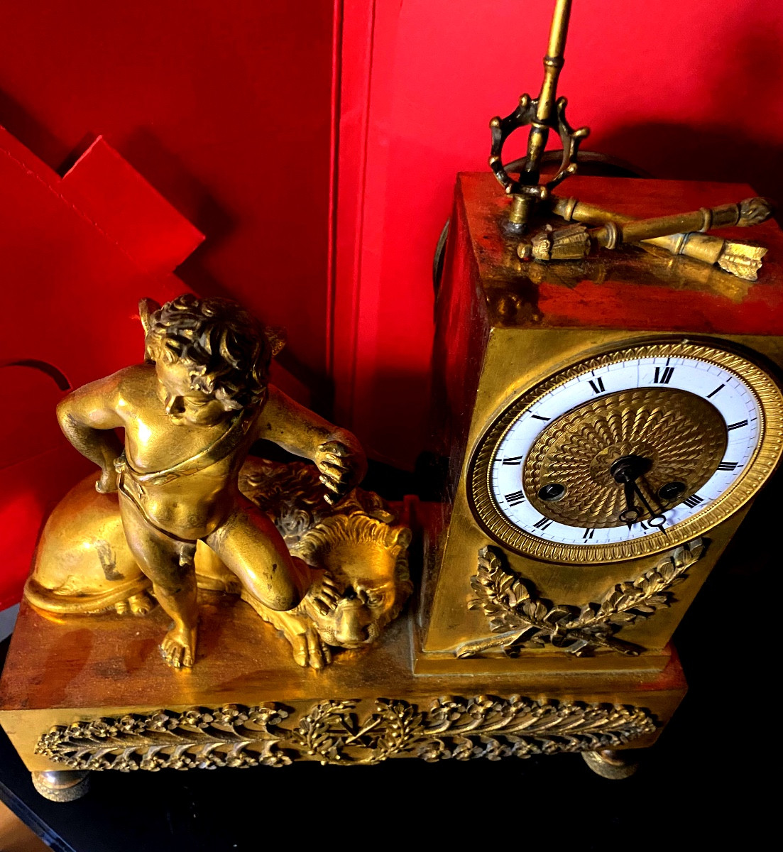 Pendule borne avec un cupidon ailé lion allongé époque Charles X en bronze doré cadran émaillé