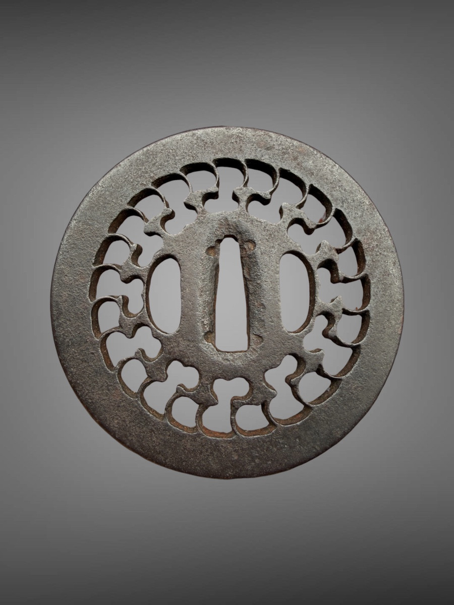 Tsuba maru-gata en fer forgé ajouré à décor d’un motif géométrique rayonnant - Période Edo. 