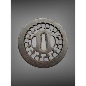 Tsuba maru-gata en fer forgé ajouré à décor d’un motif géométrique rayonnant - Période Edo.