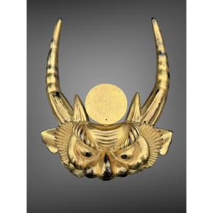 Important maedate en bois laqué or figurant une tête d’oni - Époque Edo (1603-1868).
