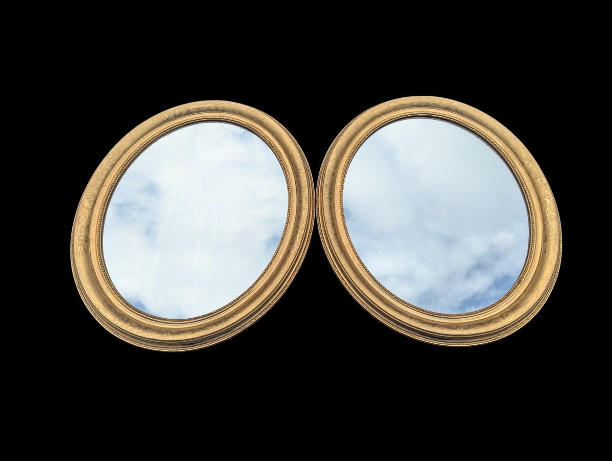 Paire de miroirs en médaillon doré 