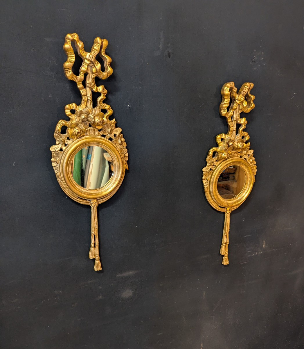 Paire de miroirs ronds en bois doré de style Louis XVI