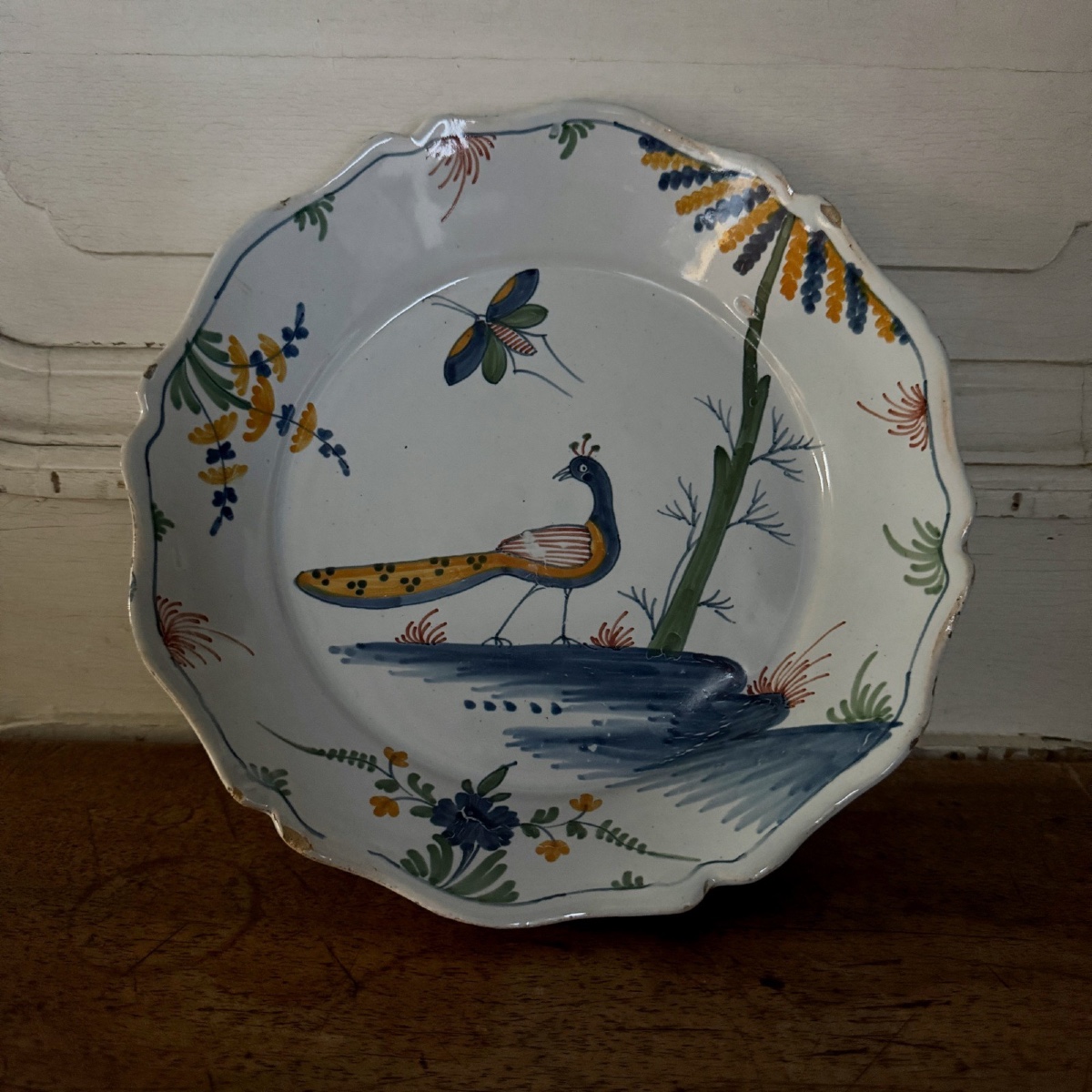 Assiette en faïence XVIIIe La Rochelle décor de paon et papillon