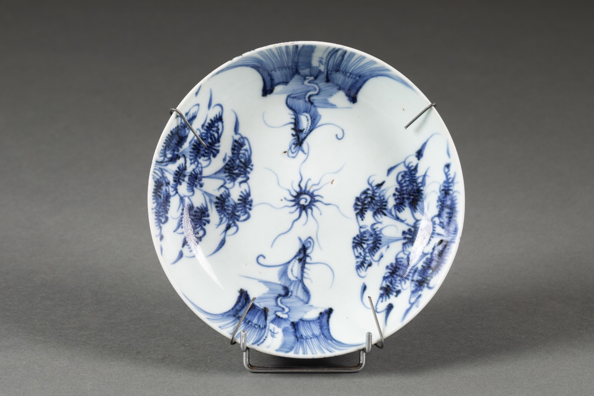 Assiette en porcelaine de Chine bleu et blanc à décor de dragons et motifs floraux