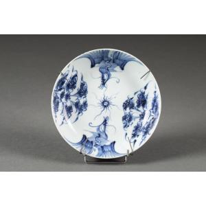 Assiette en porcelaine de Chine bleu et blanc à décor de dragons et motifs floraux