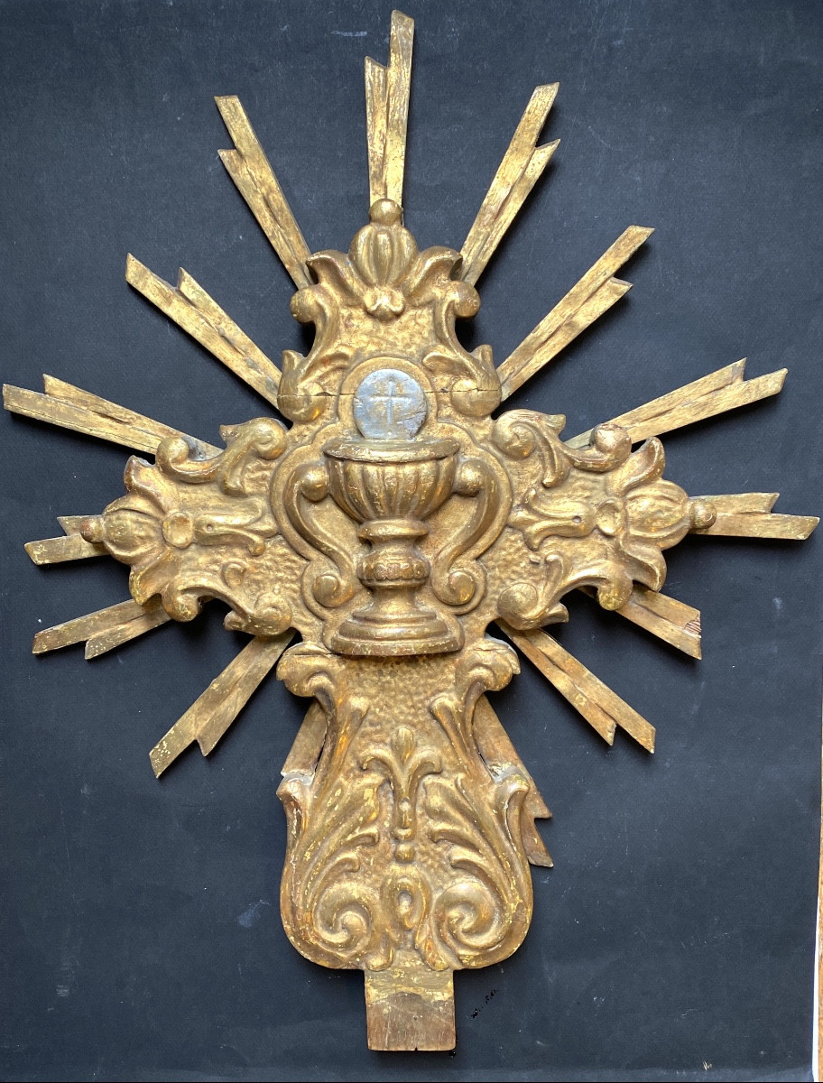 Bois sculpté et doré XVIIIème.  Croix avec Ciboire sur fond rayonnant. 