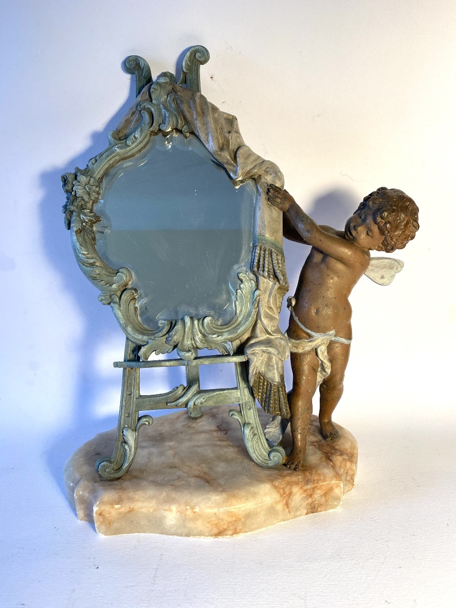 Miroir de table sur un chevalet dévoilé par un angelot. Métal patiné et marbre XIXème. 