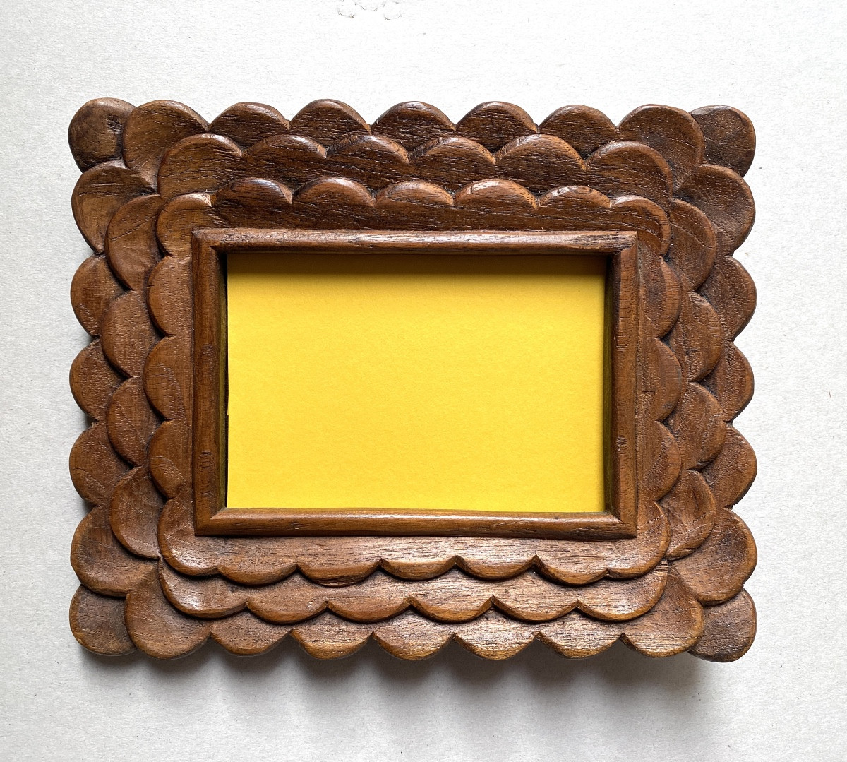 Art populaire début XXème. Cadre en bois sculpté. Décor écailles. 
