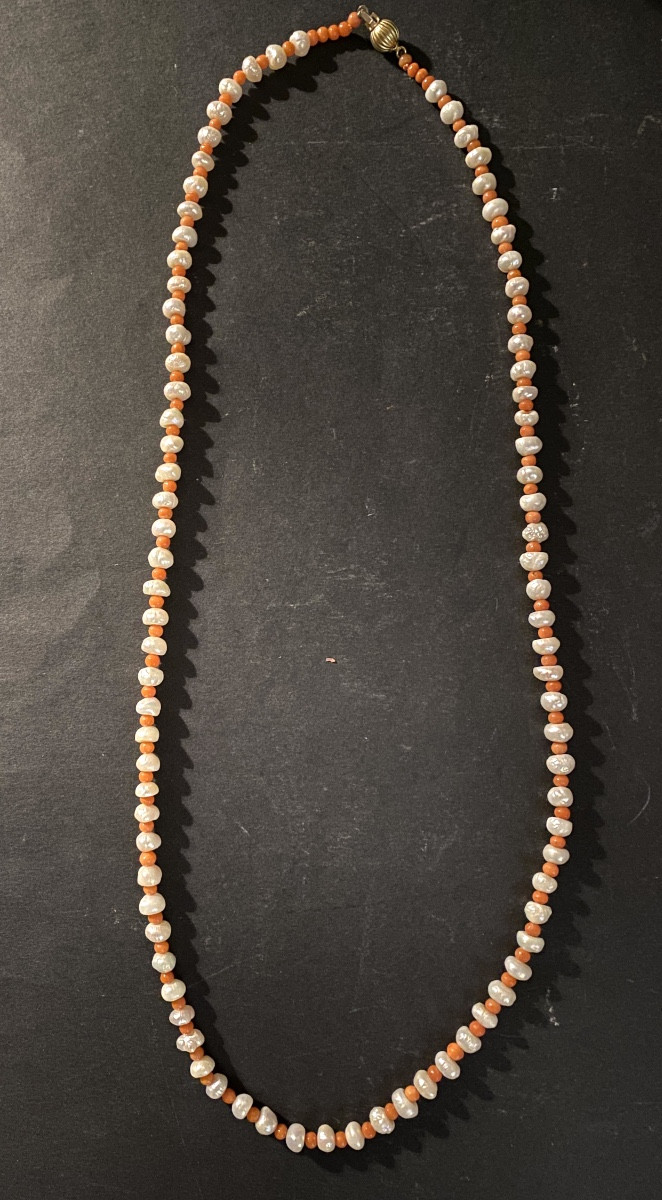 Sautoir en perles de culture et perles de corail. Fermoir en or 18k. Milieu XXème.