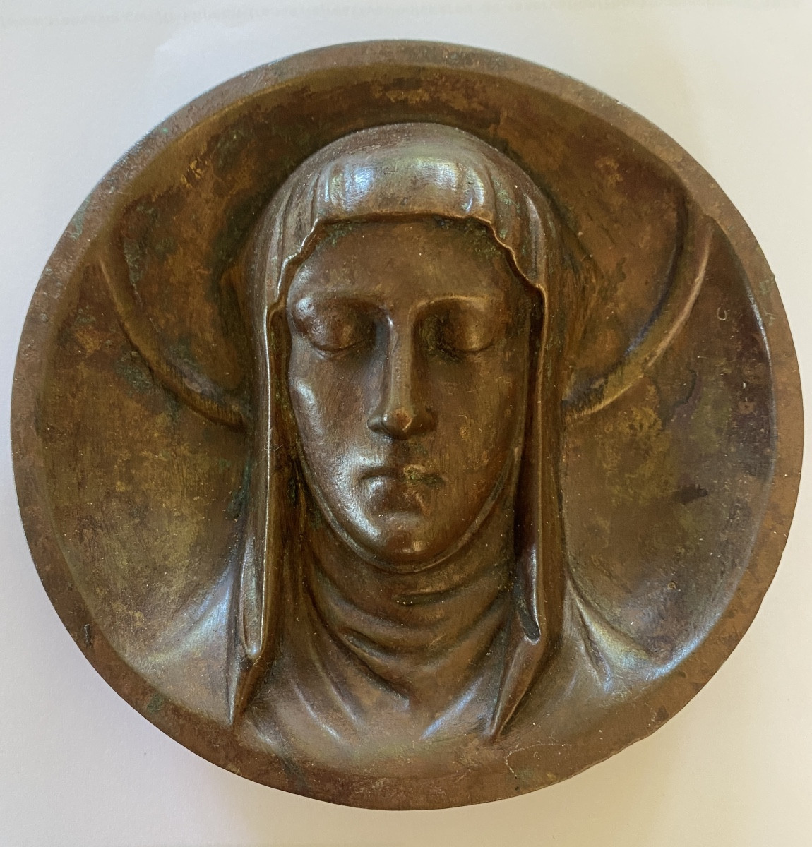 Médaillon en bronze à patine brune XIXème. Visage auréolé en haut relief de la Vierge Marie. 