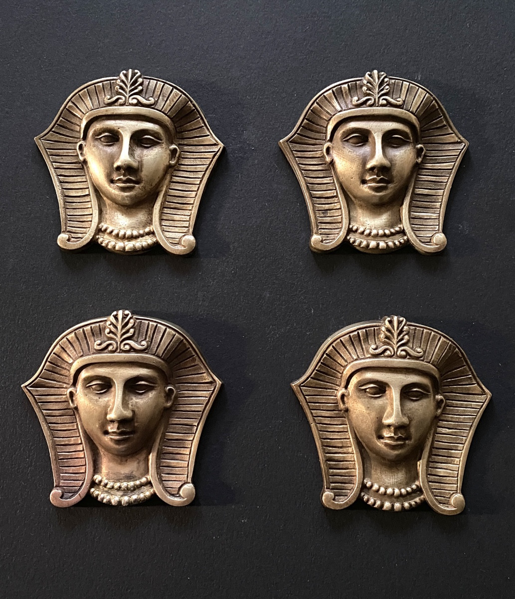 Egyptomania. Suite de quatre bronzes d’ornement XIXème. Visages de pharaons.
