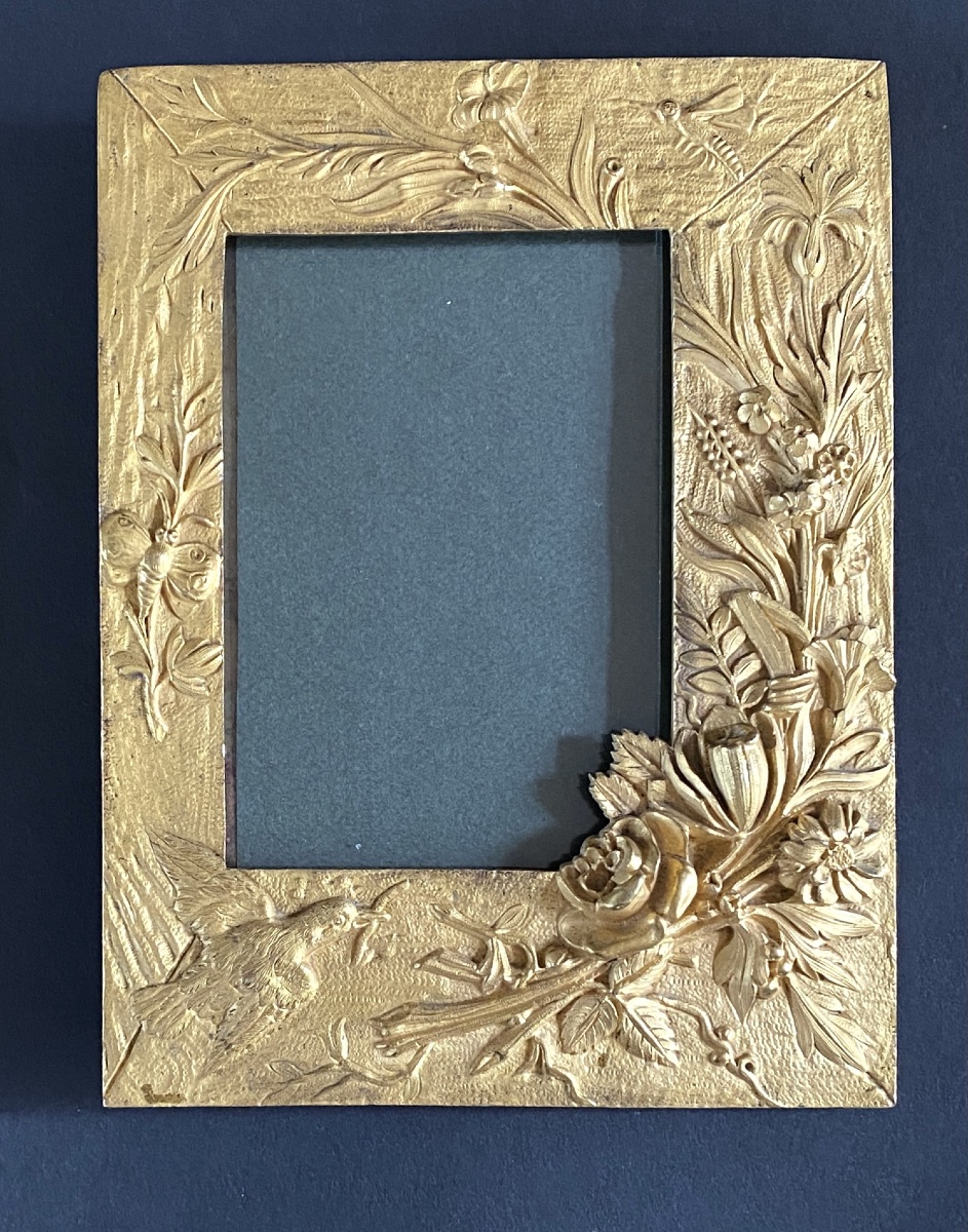 Cadre en bronze doré XIXème. Décor en relief fleurs, papillons et oiseau. 