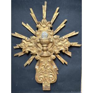 Bois sculpté et doré XVIIIème.  Croix avec Ciboire sur fond rayonnant. 
