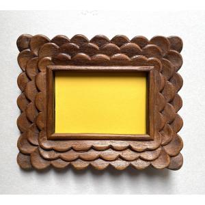 Art populaire début XXème. Cadre en bois sculpté. Décor écailles. 