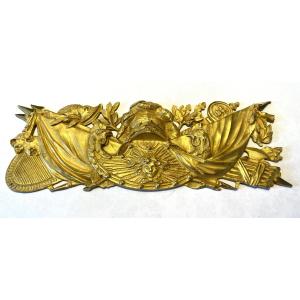 Plaque d’ornement en bronze doré XIXème. Trophées et attributs militaires entourant Apollon.